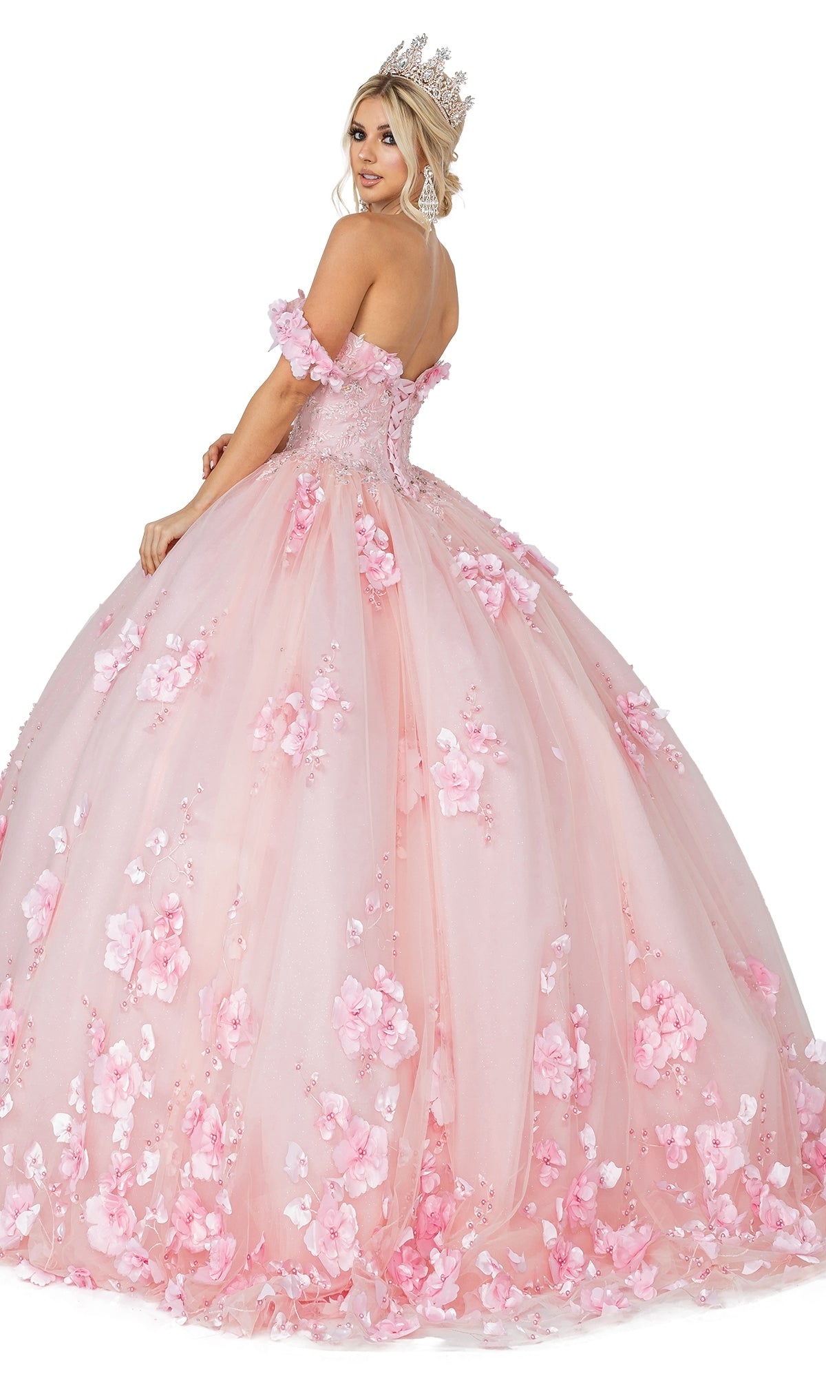 A woman poses against a white background wearing the Quinceanera Dress 1613 by Dancing Queen, a large off-the-shoulder ball gown with floral embellished appliqués and a tiara.